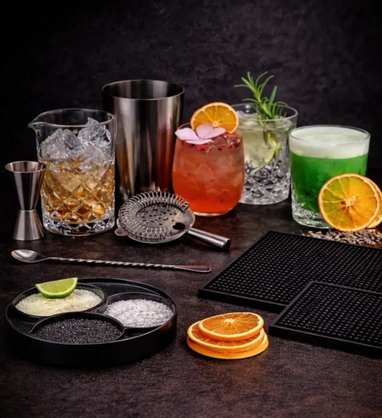 Hausbar Setup mit Boston Shaker, Jigger, Barsieb, Barlöffel und alkoholfreien Cocktails auf dunklem Hintergrund